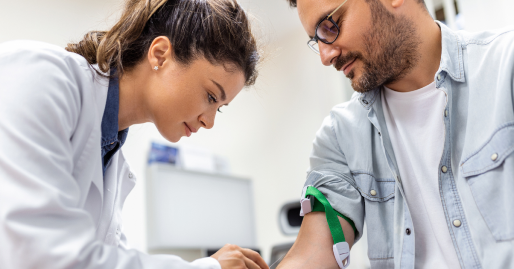 Woman in clinic drawing blood from a man.