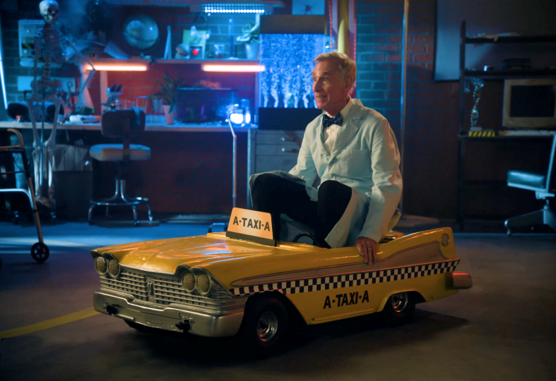 Alternate Bill Nye sitting in taxi labeled "A-Taxi-A"
